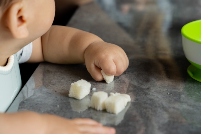 小さな物をおや指と人差し指でつまむ9か月児